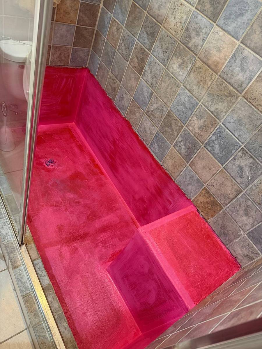Shower pan after fresh concrete pour with proper slope to the drain, coated in two-level waterproofing membrane